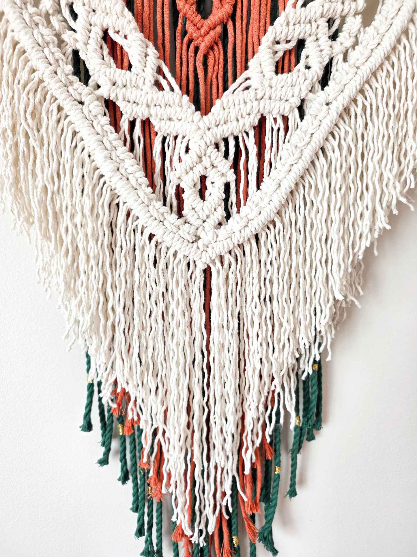 Gros plan sur les nœuds de macramé ivoire et terracotta du mural Kaïa – détail artisanal fait main, Une Histoire De Noeud