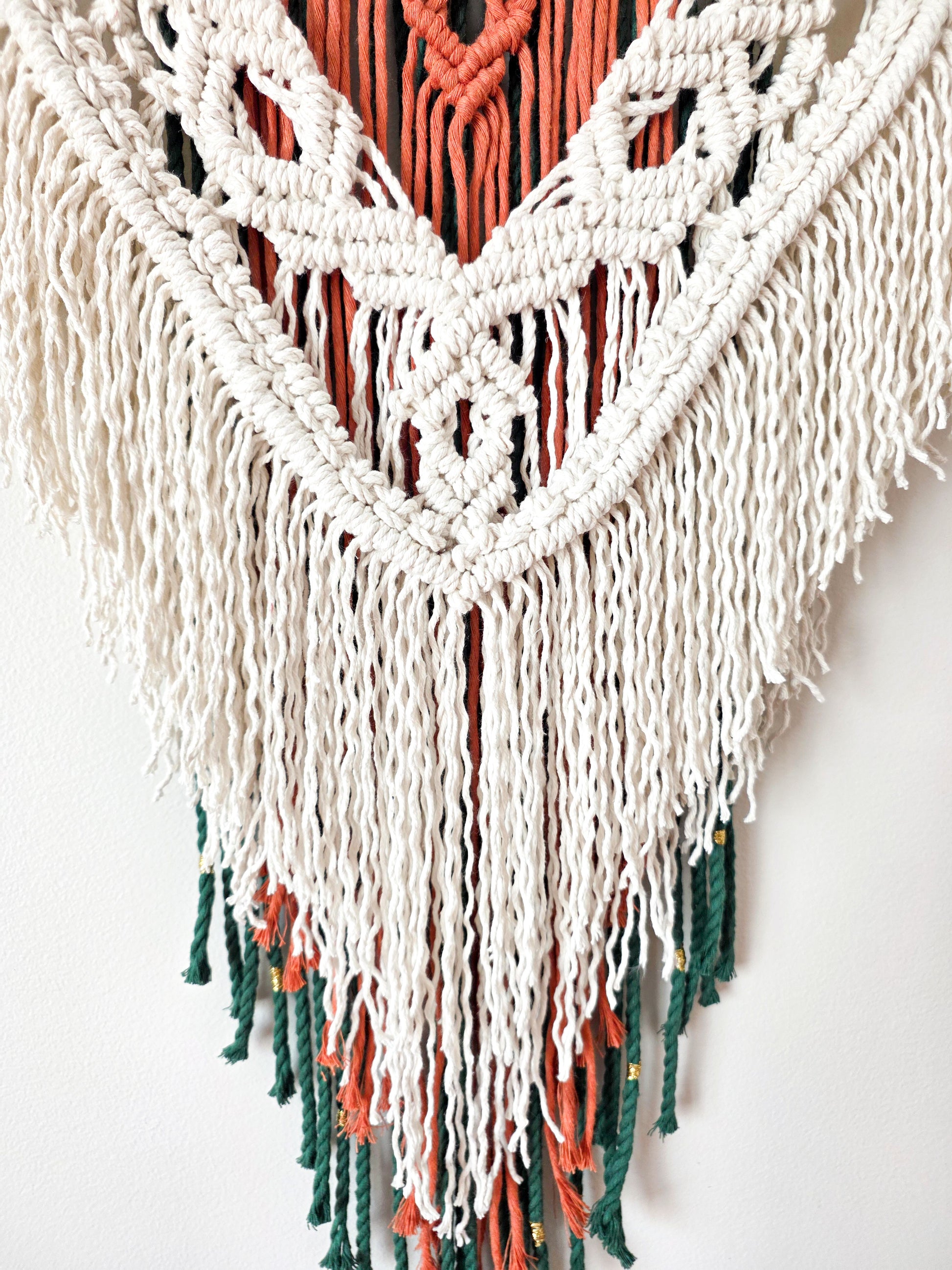 Gros plan sur les nœuds de macramé ivoire et terracotta du mural Kaïa – détail artisanal fait main, Une Histoire De Noeud